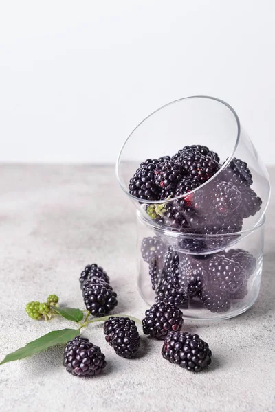 Taças de vidro com amoras saborosas na mesa cinza — Fotografia de Stock