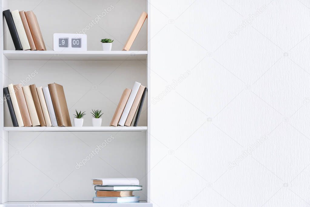 Shelf unit with books near white wall