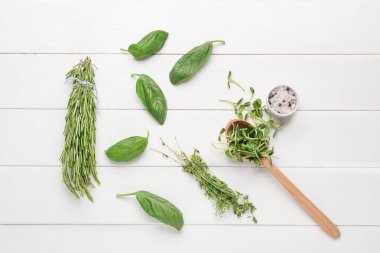 Beyaz ahşap arka plan üzerinde farklı taze otlar ve baharatlar