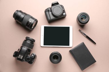 Tablet bilgisayar ve renkli arka planda fotoğrafçının donanım seti