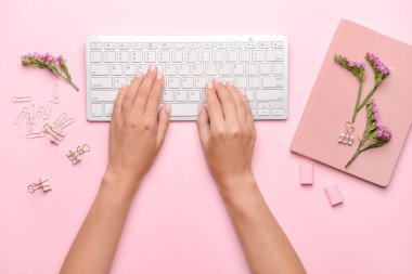 Renkli arka planda Pc klavye, dizüstü bilgisayar ve çiçekler ile kadın eller