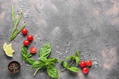 Gri arka planda baharat, domates ve limon ile taze otlar