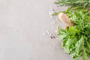 Gri arka plan üzerinde baharat ile harç taze arugula