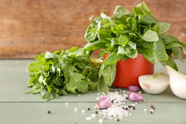 Ahşap masada sebze ve baharatlar ile farklı taze otlar