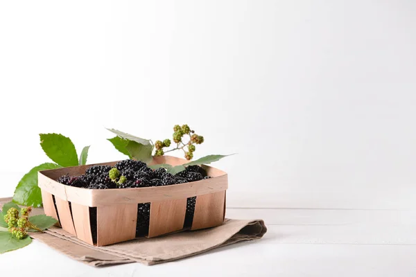 Basket with fresh blackberries on white table — Stock Photo, Image