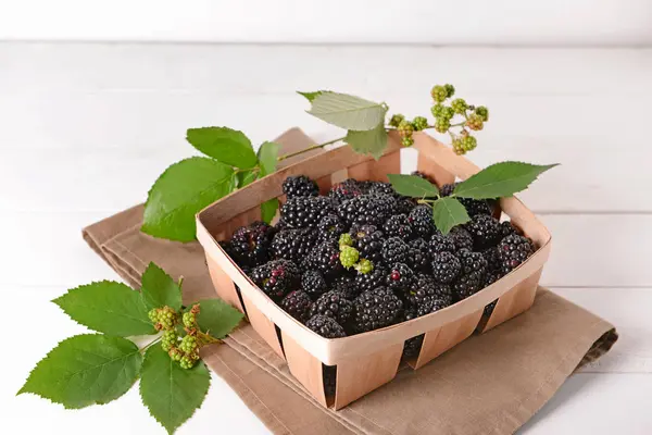 Cesta com amoras frescas na mesa branca — Fotografia de Stock