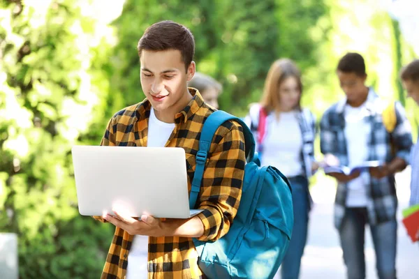 Jeune étudiant avec ordinateur portable à l'extérieur — Photo
