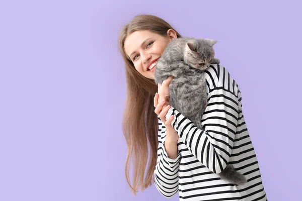 Hermosa mujer joven con gato lindo en el fondo de color — Foto de Stock
