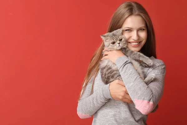 Bella giovane donna con gatto carino su sfondo di colore — Foto Stock