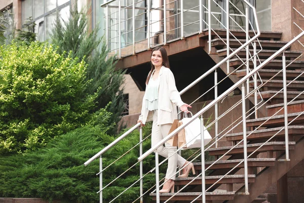 Hermosa mujer con bolsas de compras en las escaleras al aire libre —  Fotos de Stock