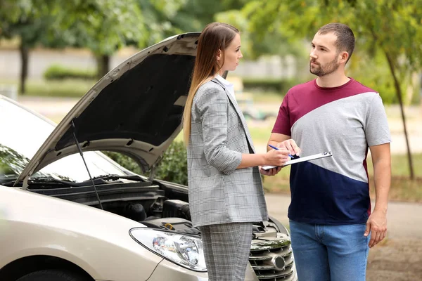 Giovane uomo e agente assicurativo vicino auto danneggiata all'aperto — Foto Stock