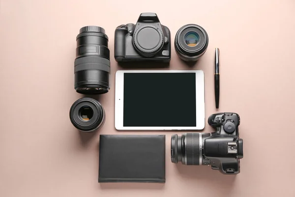 Tablet computer and set of photographer's equipment on color background — Stock Photo, Image