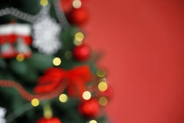 Vista offuscata di bellissimo albero di Natale su sfondo a colori, primo piano — Foto Stock