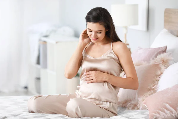 Красивая беременная женщина в спальне — стоковое фото