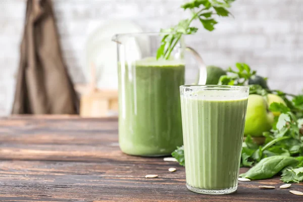 Copo e jarro de smoothie saudável na mesa — Fotografia de Stock