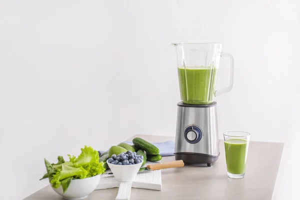 Glas hälsosam smoothie, mixer och ingredienser på bordet — Stockfoto