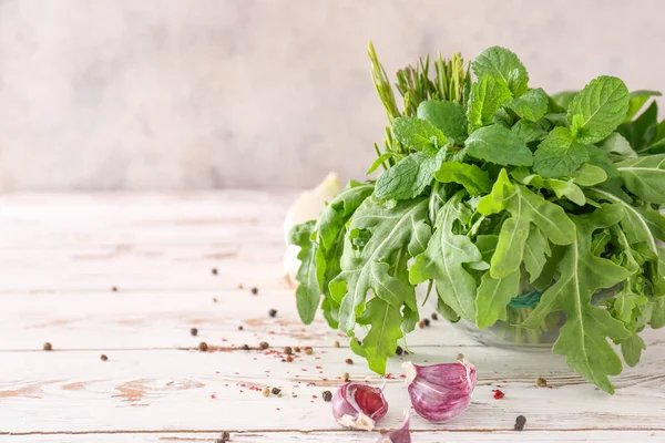 Färska örter med kryddor och vitlök på vitt träbord — Stockfoto