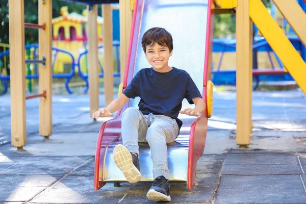 Cute little boy on slide in park — Stock Photo, Image