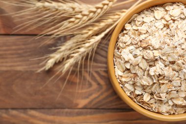 Ahşap masa üzerinde çiğ yulaf ezmesi ile kase