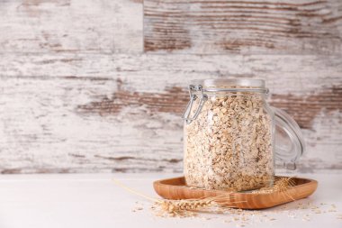 Ahşap masa üzerinde ham yulaf ezmesi ile Kavanoz