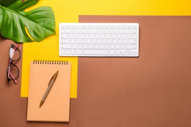 Renkli arka planda kırtasiye ve gözlük ile modern bilgisayar klavyesi