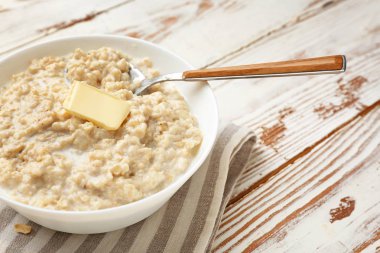 Beyaz ahşap masada lezzetli yulaf ezmesi ile Kase