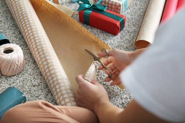 Yerde Noel hediyesi yapan kadın