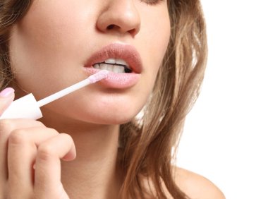 Beyaz arka plan, closeup karşı ruj uygulayan güzel genç kadın