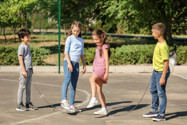 Cute little children jumping rope on playground — Stock Photo, Image