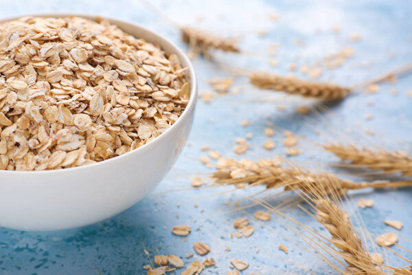 Чаша с сырой овсянкой на цветном фоне, крупным планом
