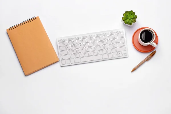 Modern computer keyboard with stationery and cup of coffee on white background — Stock Photo, Image