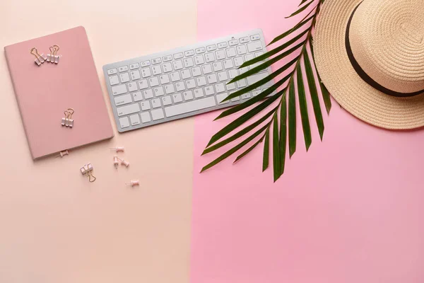 Modern computer keyboard with stationery and hat on color background — Stock Photo, Image