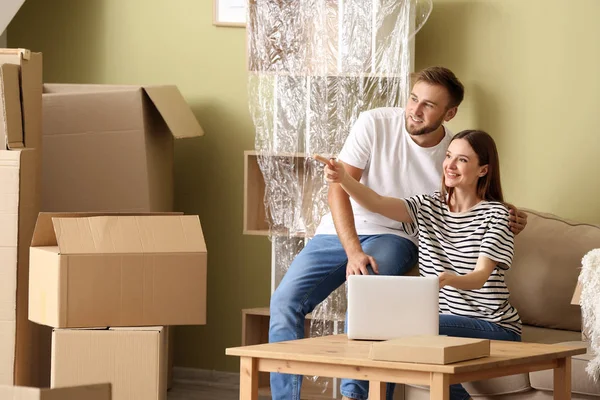 Junges Paar mit Laptop bei der Planung seines neuen Hauses — Stockfoto