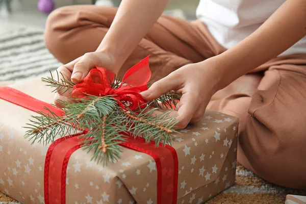 Woman with beautiful Christmas gift sitting on floor, closeup — Stock Photo, Image