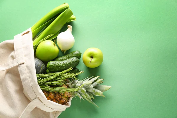 Eco bag with products on color background