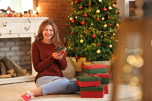 Glückliche junge Frau mit Weihnachtsgeschenken zu Hause — Stockfoto
