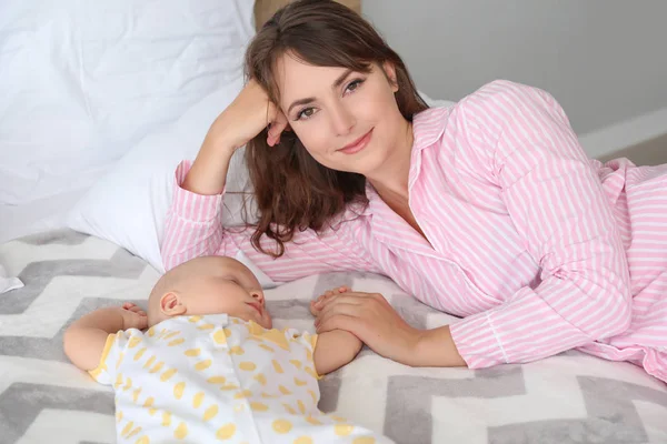 Мать и милый маленький ребенок, лежащий на кровати — стоковое фото