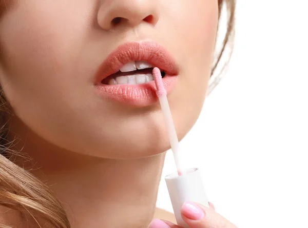 Hermosa joven aplicación de lápiz labial sobre fondo blanco, primer plano — Foto de Stock