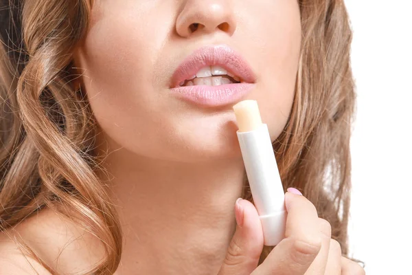 Beautiful young woman applying lipstick against white background, closeup — Stock Photo, Image