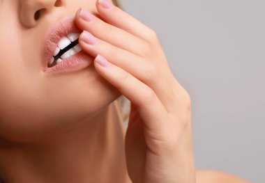 Gri arka plan, closeup üzerinde güzel genç kadın
