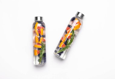 Beyaz arka planda lezzetli aşılanmış su şişeleri