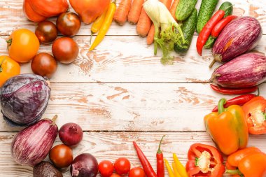 Beyaz ahşap arka planda taze sebzelerden yapılmış çerçeve