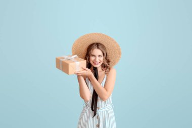 Açık renkli arka plan üzerinde hediye kutusu ile güzel genç kadın