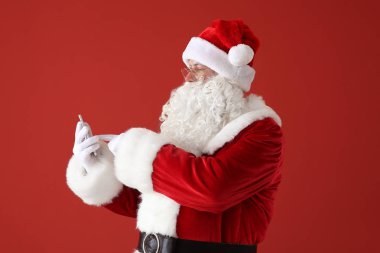 Renkli arka planda cep telefonu ile Noel Baba Portresi
