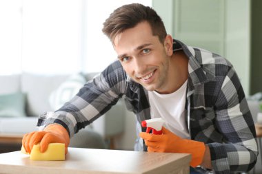 Genç adam dairesini temizliyor.