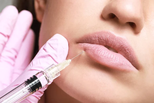Ung kvinna som får injektion av fyllmedel i läppar, närbild — Stockfoto