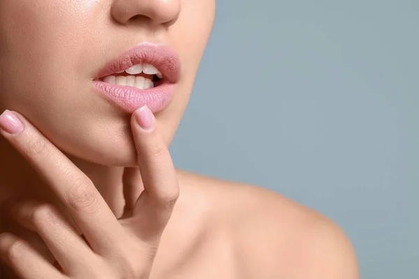 Mujer joven con hermosos labios sobre fondo de color, primer plano — Foto de Stock