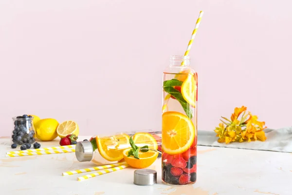 Botellas de sabrosa infusión de agua en la mesa de luz —  Fotos de Stock