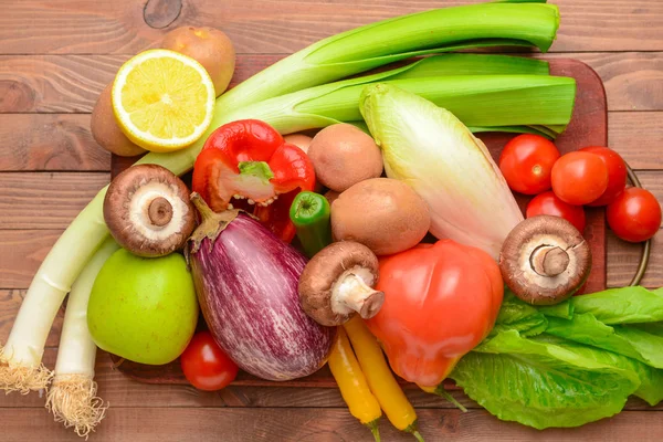 Assortment of fresh vegetables and fruits on wooden background — Stock Photo, Image