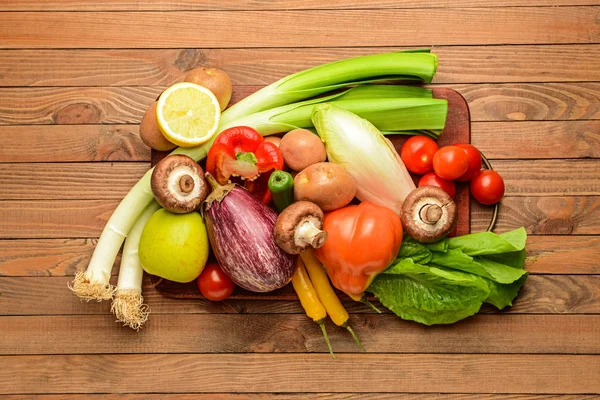 Assortment of fresh vegetables and fruits on wooden background — Stock Photo, Image